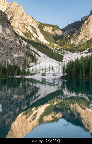 Réflexions de l'après-midi à Pragser Wildsee, Dolomites, avec des pics rocheux et des forêts de pins en été Banque D'Images