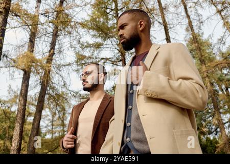 Deux hommes bien habillés se promènent dans un paysage automnal vibrant, embrassant le charme de la saison. Banque D'Images