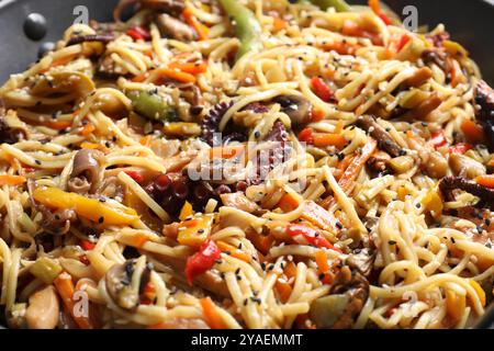 Sauter des nouilles avec des fruits de mer et des légumes dans un wok, gros plan Banque D'Images