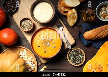 Délicieuse soupe de citrouille, épices et produits sur table en bois, plat Banque D'Images