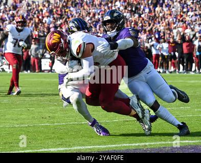 Baltimore, États-Unis. 13 octobre 2024. Le Tight End Zach Ertz (C) des commandants de Washington est arrêté avant la ligne de but par les linebackers des Baltimore Ravens Trenton Simpson (G) et Roquan Smith (d) lors de la deuxième mi-temps au M&T Bank Stadium de Baltimore, Maryland, le dimanche 13 octobre 2024. Baltimore a gagné 30-23. Photo de David Tulis/UPI crédit : UPI/Alamy Live News Banque D'Images