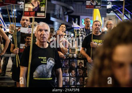 Tel Aviv, Israël. 12 octobre 2024. Les manifestants tiennent des pancartes avec des photos des otages israéliens pendant la manifestation. Des partisans ont manifesté avec des membres des familles des otages israéliens contre le premier ministre Benjamin Netanyahou, exigeant un accord immédiat sur les otages et un cessez-le-feu devant le siège des FDI. (Crédit image : © Matan Golan/SOPA images via ZUMA Press Wire) USAGE ÉDITORIAL SEULEMENT! Non destiné à UN USAGE commercial ! Banque D'Images