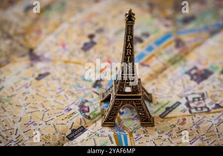 Une réplique miniature en métal de la Tour Eiffel plane sur un plan de rue de Paris en papier pour illustration et utilisation conceptuelle Banque D'Images