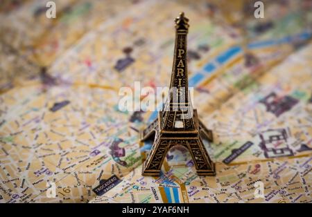 Une réplique miniature en métal de la Tour Eiffel se dresse sur un plan de rue de Paris en papier pour illustration et divertissement Banque D'Images