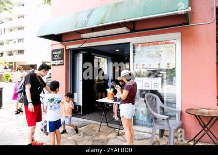 Oahu, Hawaï, États-Unis - 26 février 2024 : des clients affamés font la queue devant Maguro Spot, un magasin de nourriture japonais populaire qui propose un délicieux poke Bow Banque D'Images