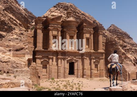 Garçon sur un cheval admirant les ruines de Petra, Jordanie Banque D'Images