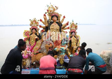 Kolkata, Bengale occidental, Inde. 13 octobre 2024. Les dévots plongent une idole de la déesse hindoue Durga dans la rivière Hoosely à Kolkata, en Inde, le 13 octobre 2024. Le festival annuel de Durga Puja est l'un des festivals les plus populaires pour les hindous. Dans la mythologie hindoue, la déesse hindoue Durga symbolise le pouvoir et le triomphe du bien sur le mal. (Crédit image : © Rupak de Chowdhuri/ZUMA Press Wire) USAGE ÉDITORIAL SEULEMENT! Non destiné à UN USAGE commercial ! Banque D'Images