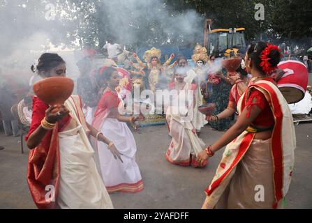 Kolkata, Bengale occidental, Inde. 13 octobre 2024. Les dévots dansent avant d'immerger une idole de la déesse hindoue Durga dans la rivière Hoosely à Kolkata, en Inde, le 13 octobre 2024. Le festival annuel de Durga Puja est l'un des festivals les plus populaires pour les hindous. Dans la mythologie hindoue, la déesse hindoue Durga symbolise le pouvoir et le triomphe du bien sur le mal. (Crédit image : © Rupak de Chowdhuri/ZUMA Press Wire) USAGE ÉDITORIAL SEULEMENT! Non destiné à UN USAGE commercial ! Banque D'Images