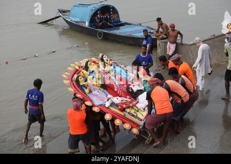 Kolkata, Bengale occidental, Inde. 13 octobre 2024. Les dévots plongent une idole de la déesse hindoue Durga dans la rivière Hoosely à Kolkata, en Inde, le 13 octobre 2024. Le festival annuel de Durga Puja est l'un des festivals les plus populaires pour les hindous. Dans la mythologie hindoue, la déesse hindoue Durga symbolise le pouvoir et le triomphe du bien sur le mal. (Crédit image : © Rupak de Chowdhuri/ZUMA Press Wire) USAGE ÉDITORIAL SEULEMENT! Non destiné à UN USAGE commercial ! Banque D'Images