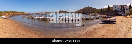 Vue panoramique de petits bateaux de pêche amarrés dans les eaux calmes de la baie de Port Lligat, située près de Cadaques, Espagne Banque D'Images