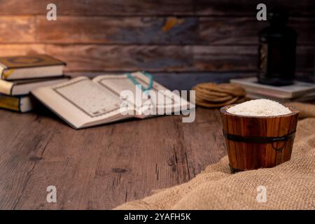 Saint Coran et un grain de riz dans un bol en bois dans le sac sur une table en bois, concept de zakat islamique. Musulmans pour aider les pauvres et les nécessiteux. Conceptuel s Banque D'Images