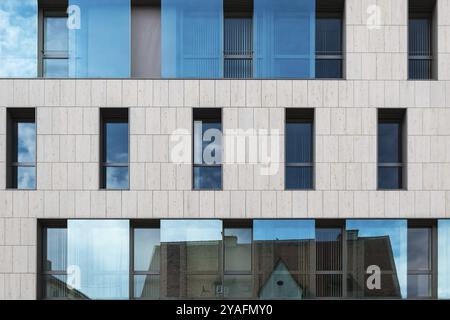 Ingolstadt, Bavière, Allemagne, 07 27 2018 : façade rectangulaire avec verre et cocnrete d'un immeuble de bureaux, reflétant un toit de ville, Europe Banque D'Images