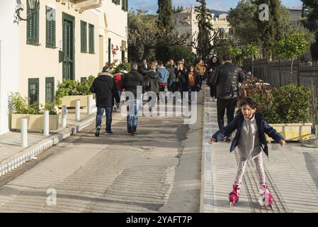 Athènes vieille ville, Attique, Grèce, 12 28 2019 enfant sur des lames de rouleau et les gens marchant dans les rues de la vieille ville autour de l'Acropole, Europe Banque D'Images