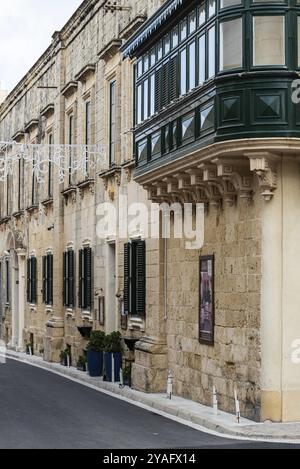 Rabat, Malte, 01 07 2022 : Rue étroite et façades de maisons résidentielles avec portes en bois et fenêtres à arc, Europe Banque D'Images