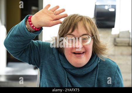 Portrait d'une joyeuse femme de 40 ans avec le syndrome de Down agitant et souriant, Tienen, Belgique, Europe Banque D'Images