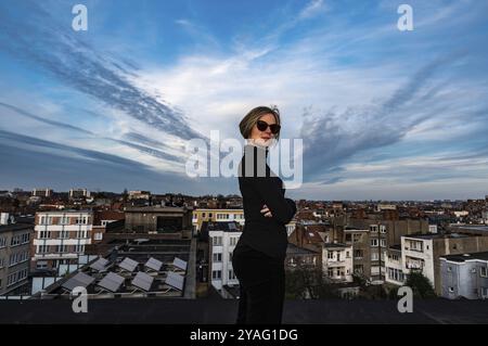 Jette, région de Bruxelles-capitale, Belgique, 03 19 2020 jolie femme blanche de trente ans avec des lunettes de soleil posant sur son toit, Europe Banque D'Images