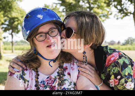 Portrait d'une jeune femme blanche embrassant une femme atteinte du syndrome de Down., Hakendover, Belgique, Europe Banque D'Images