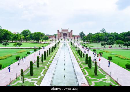 Les touristes marchent à travers les jardins moghols du complexe taj mahal à agra, en inde, vers la grande porte Banque D'Images