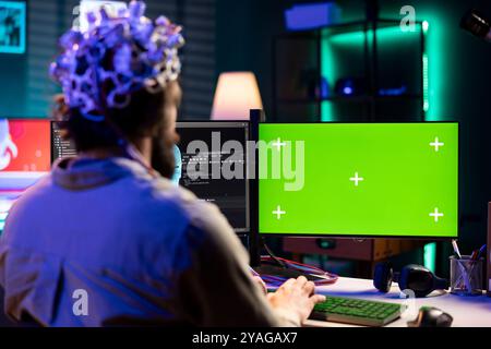 L'homme avec casque EEG programme le transfert de cerveau dans le monde virtuel d'ordinateur d'écran vert, fusionnant avec l'intelligence artificielle. Spécialiste INFORMATIQUE à la maison utilisant les neurosciences et la maquette PC pour gagner l'âme numérique Banque D'Images