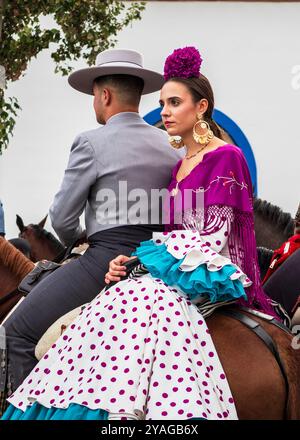Fuengirola, Malaga, Espagne. 10/11/2024. Gros plan d'un couple de cavaliers habillés en costume de cow-boy et robe à volants andalous, Banque D'Images