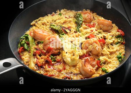 Poêle de riz au curry avec des crevettes et des légumes, cuisson d'un repas rustique fait maison, foyer sélectionné, profondeur de champ étroite Banque D'Images