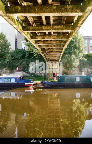 Les gens marchent et les bateaux amarrés sous la passerelle sur le canal Lancaster Banque D'Images