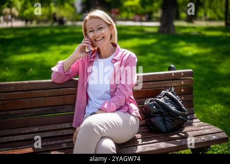 Portrait de femme mature heureuse dans le parc. Elle profite d'une journée ensoleillée dans le parc. Banque D'Images
