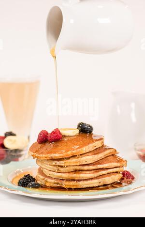 Sirop versé sur une pile de crêpes Banque D'Images