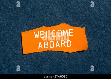 Message de bienvenue à bord écrit sur un morceau de papier orange déchiré déchiré avec fond de feutre gris. Bienvenue conceptuel à bord du symbole. Copier l'espace. Banque D'Images