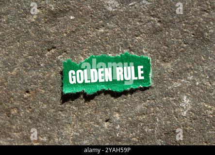 Message de règle d'or écrit sur un morceau de papier déchiré vert déchiré avec fond de pierre. Symbole de règle d'or conceptuelle. Copier l'espace. Banque D'Images