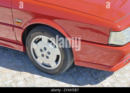 Gros plan d'une renault 21 turbo rouge garée dans une rue pavée, mettant en valeur son design sportif et son attrait classique Banque D'Images