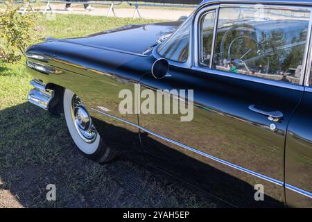 Coupé cadillac noir classique deville est garé sur l'herbe avec son chrome brillant au soleil Banque D'Images