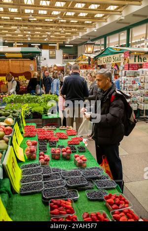 Royaume-Uni, Angleterre, Shropshire, Shrewsbury, Market Hall intérieur, homme à l'étal de fruits et légumes Banque D'Images