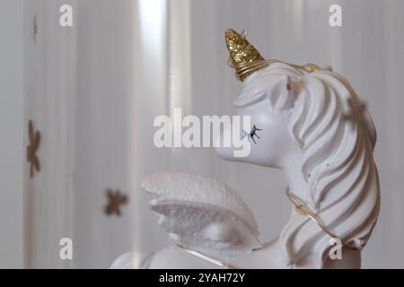 Gros plan d'une figurine de licorne blanche avec Corne d'or Banque D'Images