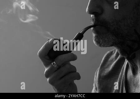 Homme fumant une pipe en noir et blanc avec Soft Smoke Trail Banque D'Images