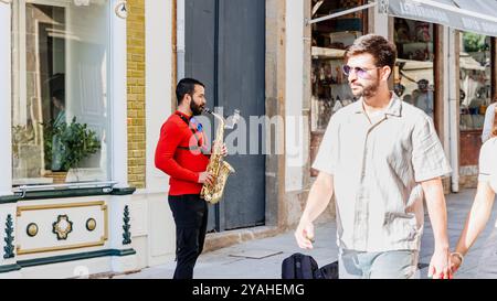 Braga, Portugal - 26 mai 2024 : saxophoniste jouant dans une rue du centre historique de la ville pendant l'événement Braga Romana Banque D'Images