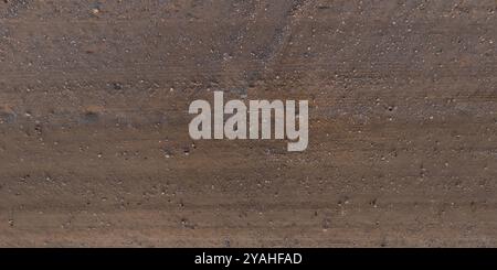 vue de dessus sur la texture de la route boueuse sèche avec des traces de pneus de tracteur dans la campagne Banque D'Images