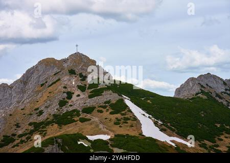 Sentier de randonnée accidenté menant au sommet de la montagne avec une grande croix sous ciel nuageux. Montagnes des Tatra à Zakopane, Pologne. Sommet de la montagne Giewont. Natura Banque D'Images