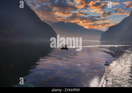 7 septembre, 2024 Flam, Norvège Un bateau de tourisme ÒspeedyÓ Fjord Safari écume l'Aurlandsfjord dans la lumière tôt le matin - vu de l'ele Banque D'Images