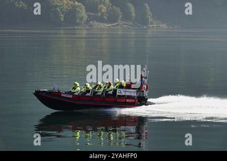 7 septembre, 2024 Flam, Norvège Un bateau de tourisme ÒspeedyÓ Fjord Safari écume l'Aurlandsfjord dans la lumière tôt le matin - vu de l'ele Banque D'Images