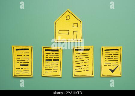 Un symbole de maison et des contrats signés. Accords immobiliers et transactions immobilières. Banque D'Images