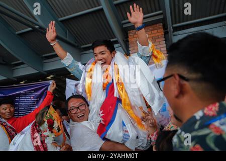 Katmandou, Népal. 14 octobre 2024. Un parent porte Nima Rinji Sherpa, 18 ans, la plus jeune personne à avoir culminé les 14 plus hauts sommets du monde au-dessus de 8000m, à son arrivée à l'aéroport international de Tribhuvan. Nima Rinji Sherpa est entré dans l'histoire en surpassant le record du monde de 2019 de son oncle à l'âge de 30 ans, devenant la plus jeune personne à atteindre les 14 plus hauts sommets du monde alors qu'elle était encore adolescente. Crédit : SOPA images Limited/Alamy Live News Banque D'Images