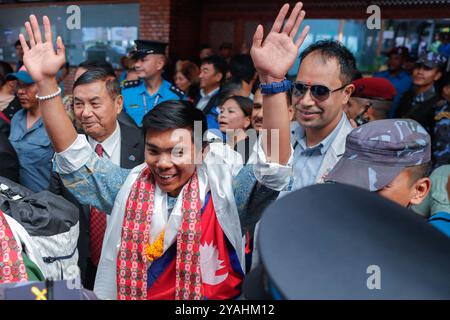 Katmandou, Népal. 14 octobre 2024. Nima Rinji Sherpa, 18 ans, la plus jeune personne à avoir culminé les 14 plus hauts sommets du monde au-dessus de 8000m, fait des gestes à son arrivée à l'aéroport international Tribhuvan de Katmandou. Nima Rinji Sherpa est entré dans l'histoire en surpassant le record du monde de 2019 de son oncle à l'âge de 30 ans, devenant la plus jeune personne à atteindre les 14 plus hauts sommets du monde alors qu'elle était encore adolescente. Crédit : SOPA images Limited/Alamy Live News Banque D'Images