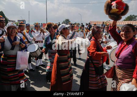 Katmandou, Népal. 14 octobre 2024. Des femmes vêtues de vêtements traditionnels dansent et chantent alors que Nima Rinji Sherpa, 18 ans, la plus jeune personne à avoir culminé les 14 plus hauts sommets du monde au-dessus de 8 000 mètres, arrive à l'aéroport international de Tribhuvan. Nima Rinji Sherpa est entré dans l'histoire en surpassant le record du monde de 2019 de son oncle à l'âge de 30 ans, devenant la plus jeune personne à atteindre les 14 plus hauts sommets du monde alors qu'elle était encore adolescente. Crédit : SOPA images Limited/Alamy Live News Banque D'Images