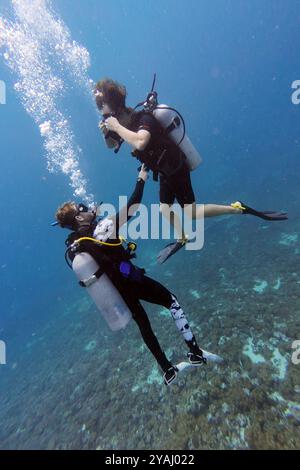 10.11.2023, Indonésie, Lombok, Gili Trawangan - hommes en cours de plongée dans la mer. 00S231110D397CAROEX.JPG [AUTORISATION DU MODÈLE : NON, AUTORISATION DU PROPRIÉTAIRE : NON (C Banque D'Images