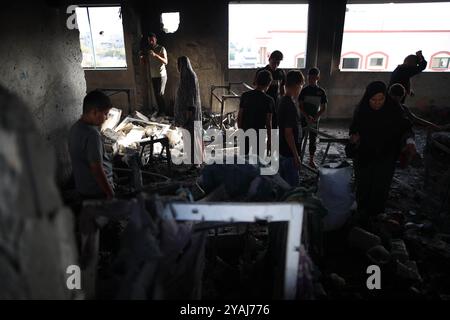 Gaza. 14 octobre 2024. Des Palestiniens sont vus dans une école hébergeant des personnes déplacées dans le camp de Nuseirat dans le centre de la bande de Gaza après une attaque israélienne, le 14 octobre 2024. Au moins 19 Palestiniens ont été tués et des dizaines d’autres blessés dimanche dans le bombardement israélien d’une école hébergeant des personnes déplacées dans le camp de réfugiés de Nuseirat, dans le centre de la bande de Gaza, selon des sources palestiniennes. Crédit : Marwan Dawood/Xinhua/Alamy Live News Banque D'Images