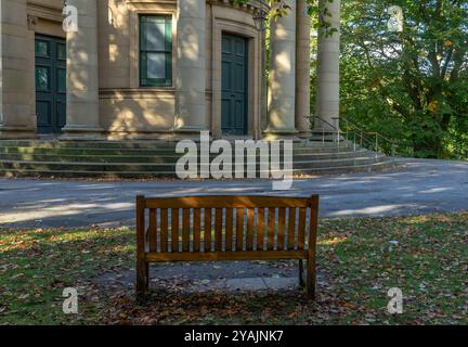 Un siège en bois dans le parc de l'église réformée unie Saltaire, Yorkshire. Ce bâtiment classé Grade 1 se trouve dans le village victorien modèle de Saltaire. Banque D'Images