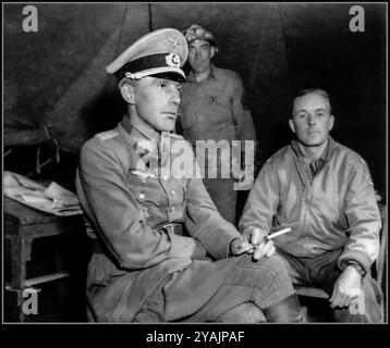 Officier nazi des prisonniers de guerre de la Wehrmacht Lieutenant général Otto Elfeldt, 1944 fumant calmement une cigarette avant son interrogatoire à Saint Lambert sur Dive. Le Generalleutnant Elfeldt, commandant de l'AK LXXXIV, est capturé avec 29 officiers, près de Moissy le 20 août 1944 par le 10e régiment de chasseurs de chevaux (Pulk Strzelcow Konnych), régiment de reconnaissance 1re division blindée polonaise. Il apparaît ici en compagnie d'un soldat américain du 701st Tank Destroyer Bn. Le 20,1944 août Normandie France il est capturé par les forces alliées en septembre 1944 lors de la retraite des forces allemandes dans le nord de la France. Banque D'Images