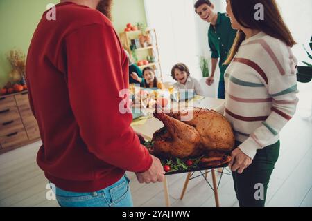 Photo de gens heureux chrétiens servant des vacances de table farcie cuit savoureux dinde tradition Thanksgiving jour à l'intérieur Banque D'Images