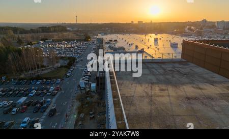Vue aérienne d'un grand parking et du toit du bâtiment au coucher du soleil. Banque D'Images
